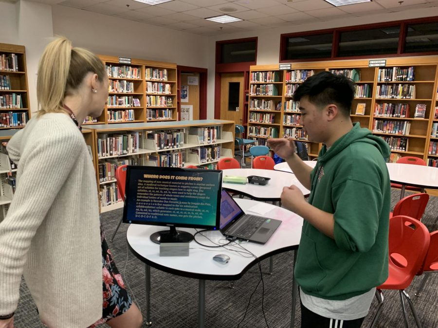 Junior Wes Kim presents his project to math teacher Mary Fierabend. 