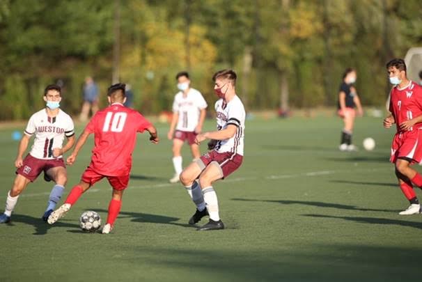 Senior co-captain’s Jackson Tabors and Nick Ginovker defends a                                                                                                    Waltham player in their soccer match. 
