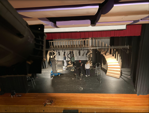 Stage crew members setting up the backdrop for the musical