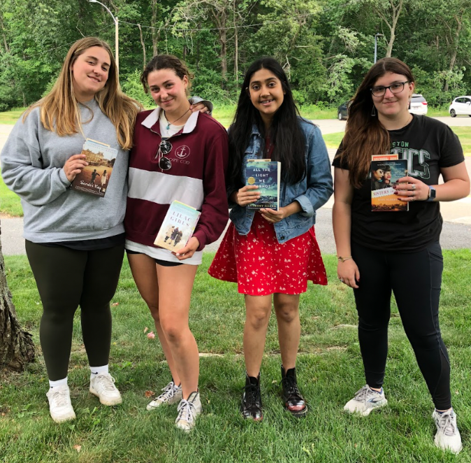 Historical fiction and World War II book club share books together outside. 