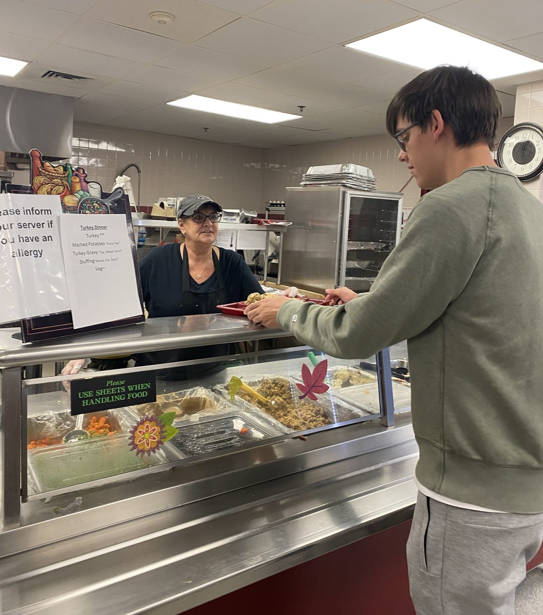 Junior Liam Strik recieves lunch from cafeteria staff