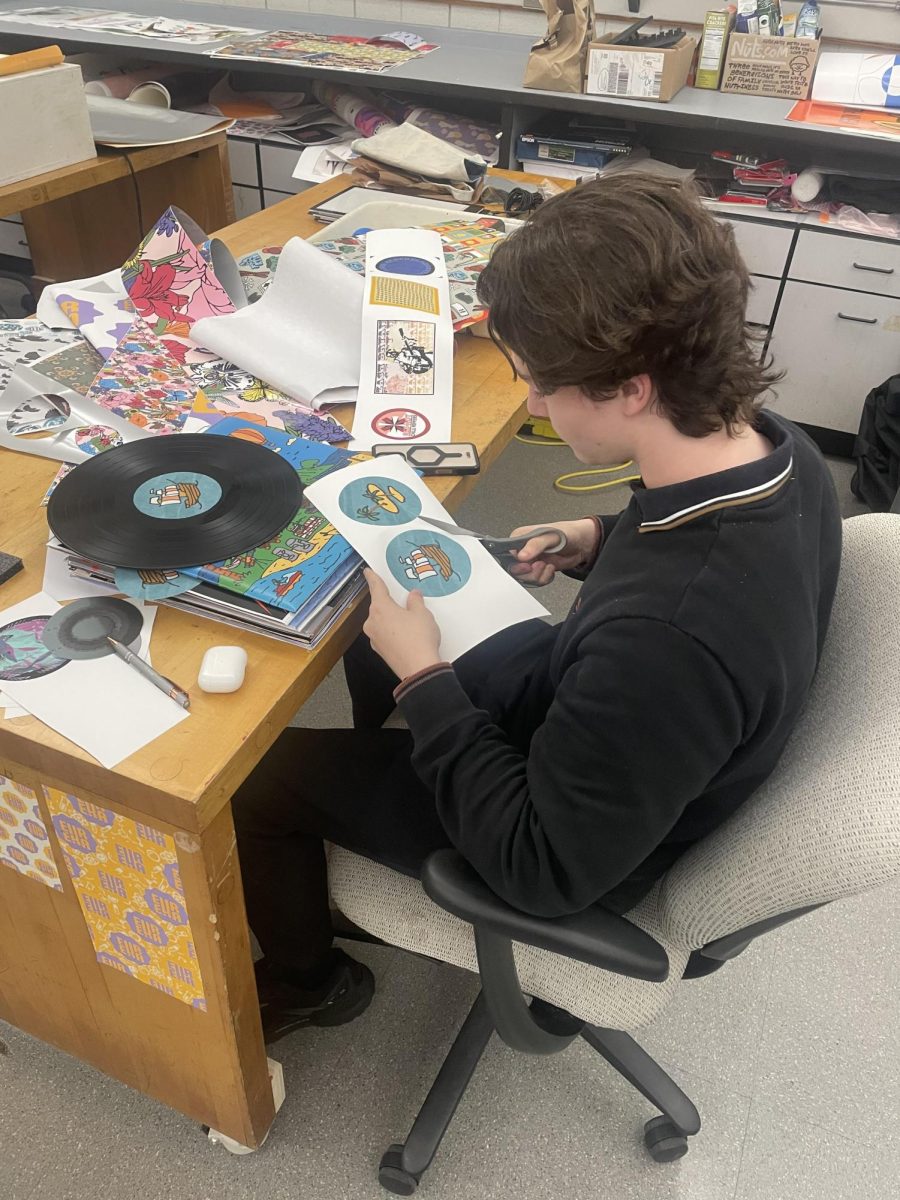 Caden Solomon works on a record cover for Graphic Design