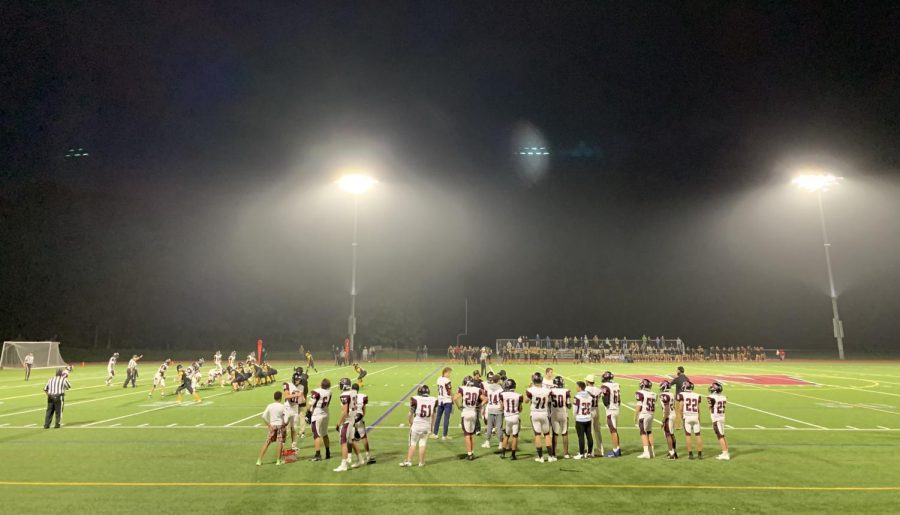 The football team gets pumped up as they play under the Friday night lights.