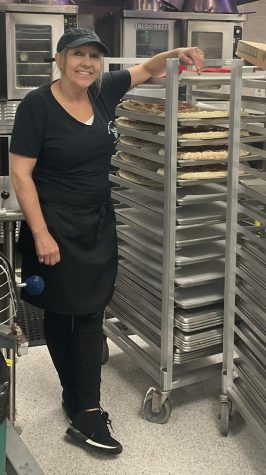 WHS food services staff member, Leanne Hough, prepares an assortment of pizzas with separate vegetarian and meat toppings. 
